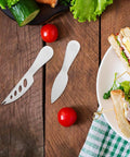 Stainless Steel Cheese Knife Set with butter spatulas and spreaders on a wooden table with salad and sandwich, perfect for camping.