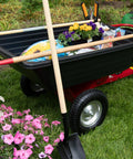 Rock Solid Six Hundred Fifty Pound Poly Dump Cart For Tough Job Site Hauling with flowers and tools visible in the cart.