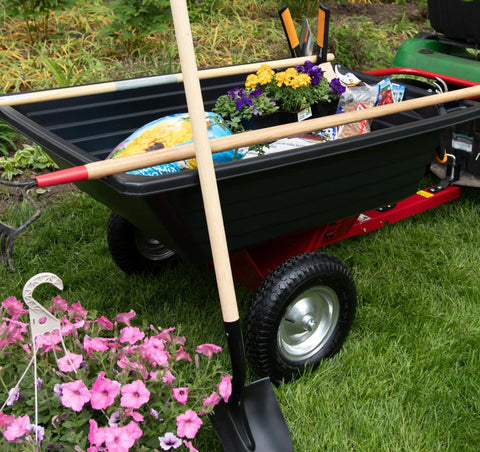 Rock Solid Six Hundred Fifty Pound Poly Dump Cart For Tough Job Site Hauling with flowers and tools visible in the cart.