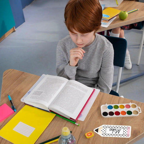 Child studying at desk with Black And White Pencil Name Tag Stickers Set 250 Pieces For Back To School Classroom Bulletin Boards.