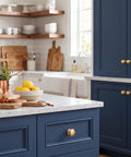 Handmade Solid Brass Cabinet Knobs Round Unlacquered Drawer Pulls Developing Rich Antique Patina Over Time Premium Kitchen Hardware on blue cabinetry.