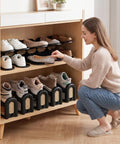 Woman organizing shoes using 12 Pack Adjustable Shoe Slot Organizers, Double Layer Closet Stackers in black.