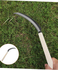 Serrated Garden Sickle With Wooden Handle For Easy Weeding And Harvesting In Small Gardens, shown against grass background.
