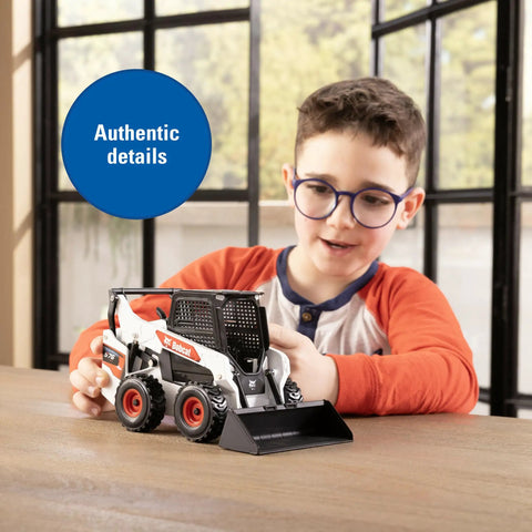 Child playing with Bobcat 1/16 Scale Skid Steer Loader Diecast Toy With Fully Functional Front Loader And Tilt Bucket Realistic Bobcat Graphics Rubber Wheels Built Tough For Kid Friendly Play And Collectors Ages Three And Up indoors.
