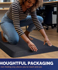 Woman kneeling on Extra Thick Anti Fatigue Standing Desk Mat With Memory Foam For Home Office All Day Comfort Ergonomic Standing Pad That Cuts Down Foot Knee And Back Strain 17 By 24 Inches Black 0.9 Inch Thick