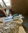Pro Series Plaster Finishing Trowel 4.5 Inch By 18 Inch Stainless Steel With Ergonomic Grip Handle on plastered surface
