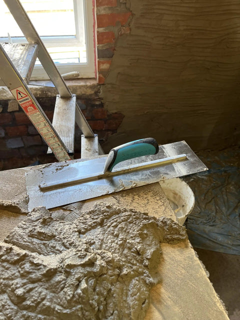 Pro Series Plaster Finishing Trowel 4.5 Inch By 18 Inch Stainless Steel With Ergonomic Grip Handle on plastered surface
