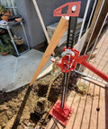 Beefy 48 Inch Ratcheting Off Road Utility Farm Jack in action, red finish, lifting setup in outdoor environment, side view