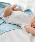 Adjustable Baby Swaddle For Newborns That Feels Like The Womb in sky color with baby sleeping arms out