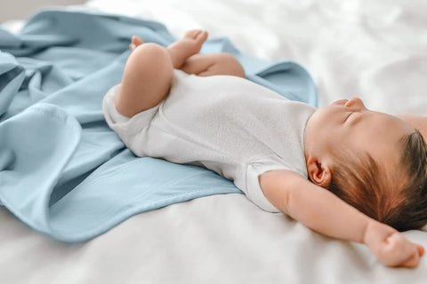 Adjustable Baby Swaddle For Newborns That Feels Like The Womb in sky color with baby sleeping arms out