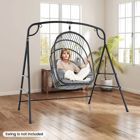 Heavy Duty Hammock Stand With A Frame For Porch Lawn Garden Backyard Supports Up To 660 Lbs Four Reinforced Crossbars Two Hanging Options Indoor Outdoor Swing Frame with person sitting in chair, swing not included, in living room setting.