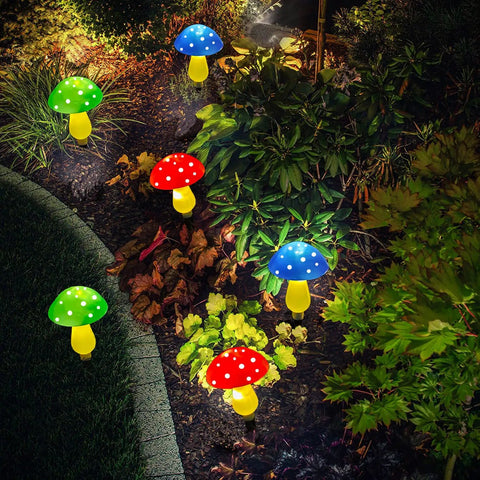Mushroom Solar Lights for Outdoors Pack of 6 LED Garden Stake Decor illuminating a garden pathway with colorful glow.