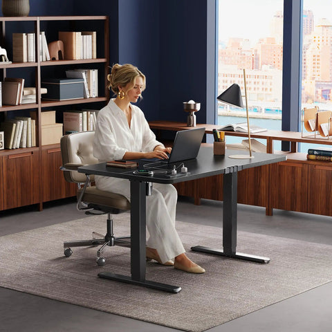 Electric Standing Desk 47 By 24 Inch With Built In Power Outlets And USB C Port Height Adjustable Sit Stand Desk in a home office.