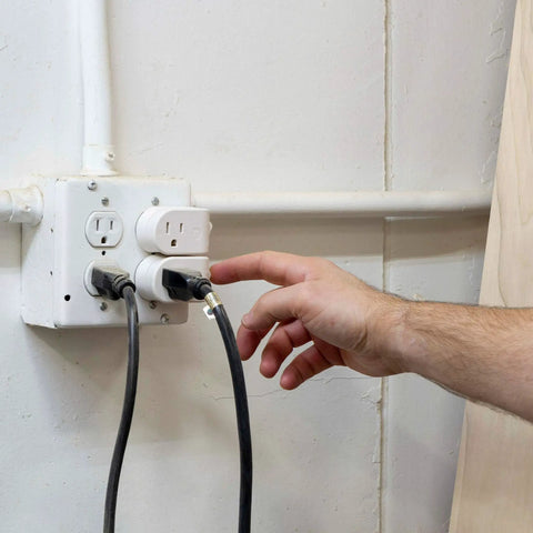 Hand using Grounded On Off Plug In Power Switch White Energy Efficient UL Listed 15A 120VAC 1800W Space Saving Design for Gadgets