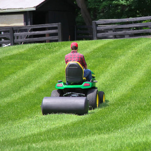 Person using Tow Behind Lawn Roller 690 Lb Capacity With Easy Turn Plug, 36 Inch Wide Poly Drum, Flat Black Finish on large lawn