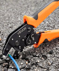 No Sweat Ratcheting Wire Crimper Pliers For 24 To 12 AWG Terminals, shown on asphalt with wire visible, ideal for electrician use.