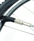 Close-up of Mountain Bike Tool Kit With Replaceable Sticks And Bracket Two Tire Levers Eight Bits Chain Breaker And A Slim Black Carry Case Portable Durable And Ready For On The Go Trail Maintenance And Quick Repairs For Everyday Riders used on a bike wheel.