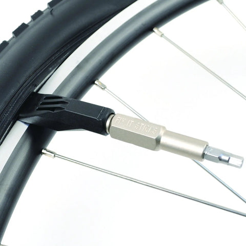 Close-up of Mountain Bike Tool Kit With Replaceable Sticks And Bracket Two Tire Levers Eight Bits Chain Breaker And A Slim Black Carry Case Portable Durable And Ready For On The Go Trail Maintenance And Quick Repairs For Everyday Riders used on a bike wheel.