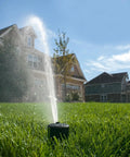 Tough As Nails Gear Drive Pop Up Lawn Sprinkler Boasting Preinstalled Number 6 Nozzle spraying across lush green lawn.