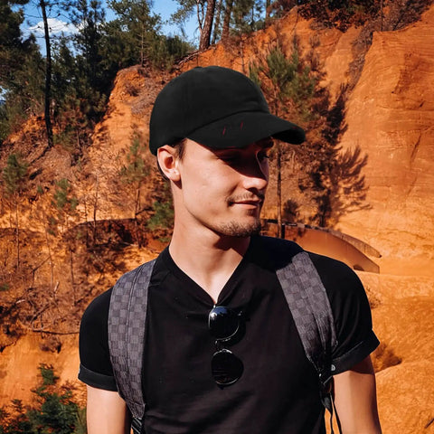 Man wearing Chill All Black Trucker Hat Ideal For Yacht Deck Crew And Charter Guests Keeps Your Head Cool With Sun Protection