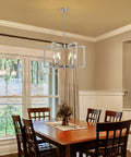 Top Tier Six Light Modern Metal Geometric Chandelier In Sleek Brushed Nickel above a wooden dining table in a cozy setting.