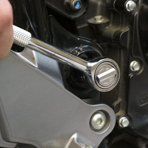 Reversible ratchet from Auto And Motorcycle 51 Piece Tool Kit Set with 6 point socket in use on a motorcycle engine.