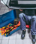 Portable Steel Toolbox 16 Inch With Double Latch Closure And Easy Carry Handle Blue Tough As Nails Heavy Duty Metal Toolbox For Workshop Garage Warehouse And Home Organization open beside mechanic under car with tools visible