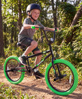 Child riding 20 Inch Freestyle BMX Bike for Beginners With 360 Degree Handlebar, 4 Pegs, U Brake in green, forest path.