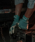 Close-up of Women's Hybrid Work And Garden Gloves With Water-Resistant HydraHyde Leather, gripping hitch, worn by person in jeans.