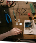 Hand arranging electronics on table with 80Pcs Spring Clamp Terminal Connectors For LED Lighting Quick Connection Barrier Blocks