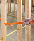 Hand using Heavy Duty Wire Dispenser For Stud Framing Mounts To 2x4 And 2x6 Wood Studs With Solid Steel Construction