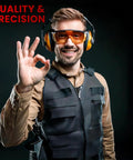 Front view of man wearing black tactical vest with orange earmuffs and safety glasses, giving an OK gesture.