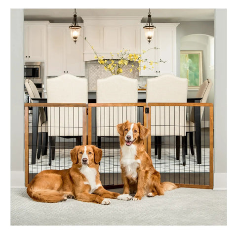 Dogs behind Extra Tall 62 Inch Wide Freestanding Wooden Pet Gate Three Panel Design With Small Pet Door in kitchen entryway.