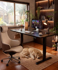 55 By 24 Inch Electric Height Adjustable Standing Desk For Home Office With Memory Preset And T Shaped Metal Bracket Big Sit Stand Computer Desk Black in modern office setup with chair and dog