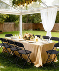 4 Pack Black Plastic Folding Chairs With Steel Frame For Outdoor Use around an elegantly set table in a garden conservatory