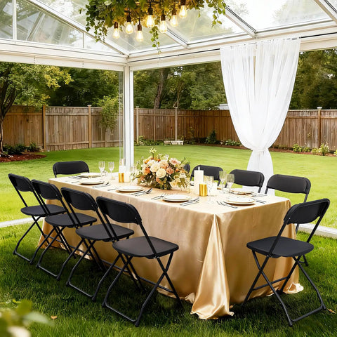 4 Pack Black Plastic Folding Chairs With Steel Frame For Outdoor Use around an elegantly set table in a garden conservatory