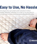 Feet resting on KenkoGround Grounding Mat for everyday recovery and calm vibes at home or office, 18 by 36 inch black grounding pad.