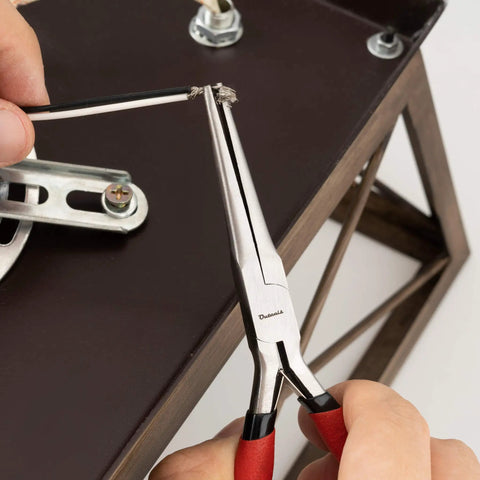 6 Inch Needle Nose Pliers With Extra Long Tapering Non Serrated Jaws gripping wire, red handles, used for wiring work