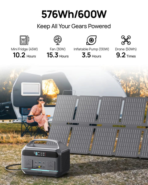 600W Portable Power Station With 576Wh LiFePO4 Battery And 100W Foldable Solar Panel on grass near a camper.