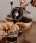 Pouring coffee from 40 Oz Thermal Coffee Carafe With Tea Infuser Stainless Steel Double Walled Vacuum Insulated Beverage Dispenser
