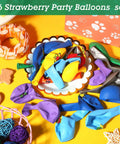 Colorful assortment of latex balloons on a table, part of a 36 Strawberry Party Balloons set.
