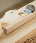Japanese Kanna Manual Hand Plane For Smoothing Woodwork with 42mm steel blade on wood surface producing shavings.