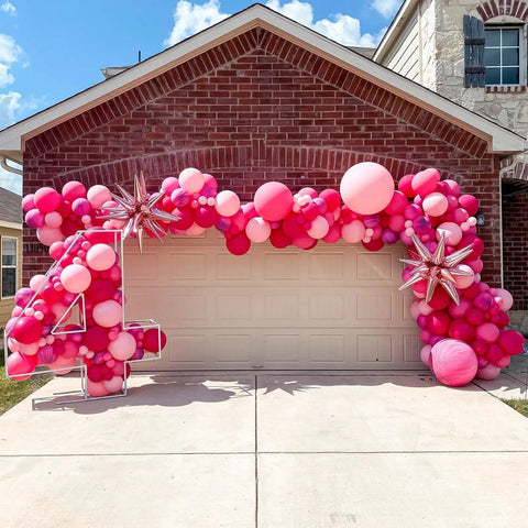 60 Piece Pink Balloons Set With 12 Inch Latex Balloons In Macaron Pink, Hot Pink, Pastel, Metallic, Matte, And Confetti Styles Plus 10m Pink And 10m Hot Pink Ribbons For Birthday Parties, Baby Showers, Weddings, And Girls Night displayed in arch over garage.