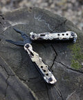 13 In 1 Outdoor Folding Multitool Pliers In Camo With Knife Saw Pliers Wire Cutter Screwdrivers Leather Punch Bottle Opener And Can Opener For Camping Fishing Hiking Survival on tree stump