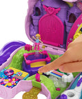 Close-up of Unicorn Party Playset With 25 Surprises, pink unicorn toy, showing a finger pointing to the castle adventure section.