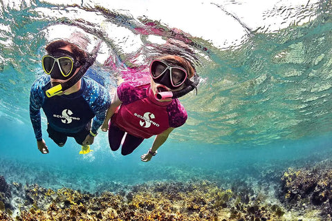Two snorkelers underwater using Spectra Dry Snorkel With Purge Valve And Quick Connect Clip Dry Top Design in coral reef.