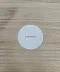 White circular label on wooden surface with the word 'Cafshion' printed, showcasing branding details.