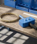 Pro Grade Power Drill Wire Puller With Heavy Duty Steel Body And Twenty Meter Fish Tape Included For Fast Track Conduit Threading No Sweat Cable Installation On Any Project Site on wooden table.