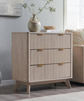 Set Of Two Fluted Nightstands Featuring Three Spacious Drawers And Clean White Alder Finish in stylish beige setting with decor.