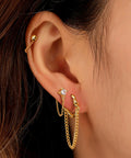 Four Pair Chain Earrings For Women With CZ Ball Studs, Dangling Front To Back Bar Huggie Hoops, Gold Tone Set, Copper Chain Drops, 3cm Length, Stainless Steel Posts, Comfortable Everyday Sparkle. Gold-tone CZ chain earrings on ear